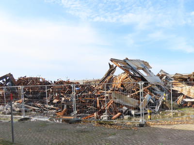 912106 Gezicht op de verwrongen metalen restanten van het uitgebrande bedrijfsverzamelgebouw Strijkviertel 35 te De ...